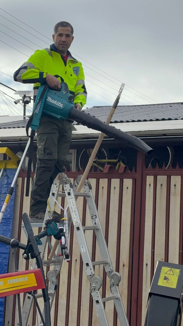 Trabajo en altura sobre escalera despejando techo