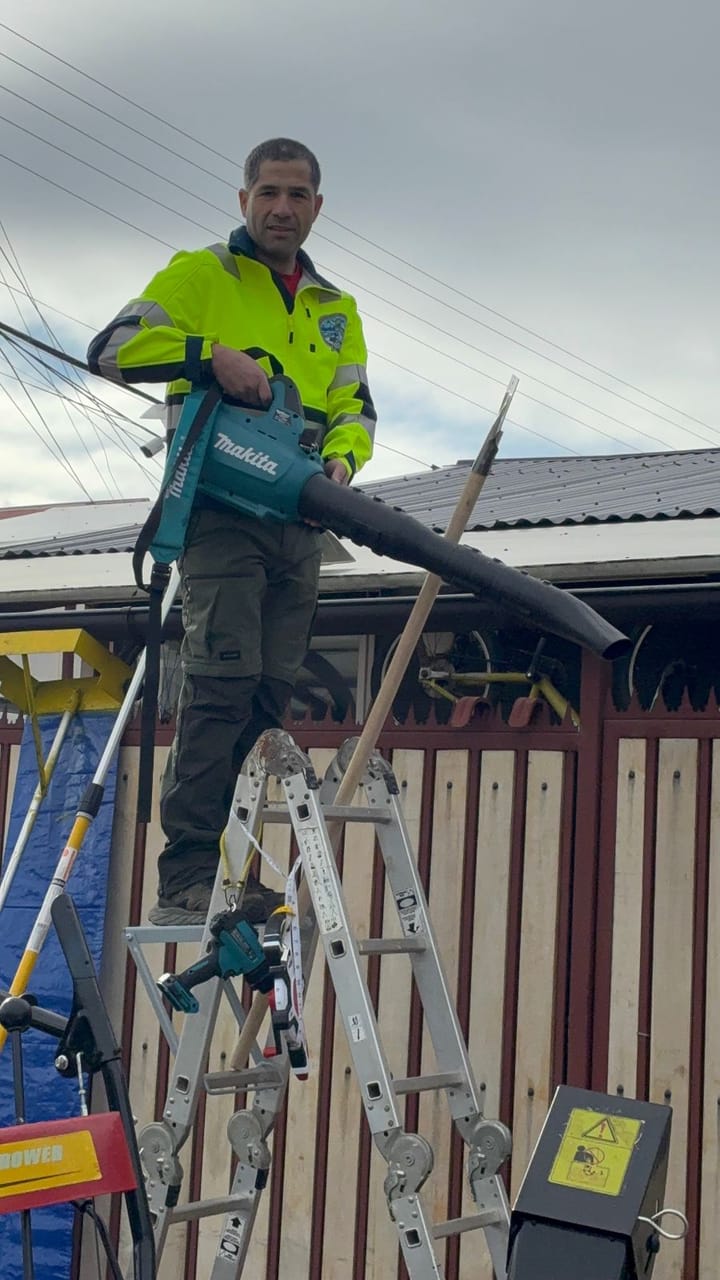 Despeje de techo con soplador desde escalera en Coyhaique